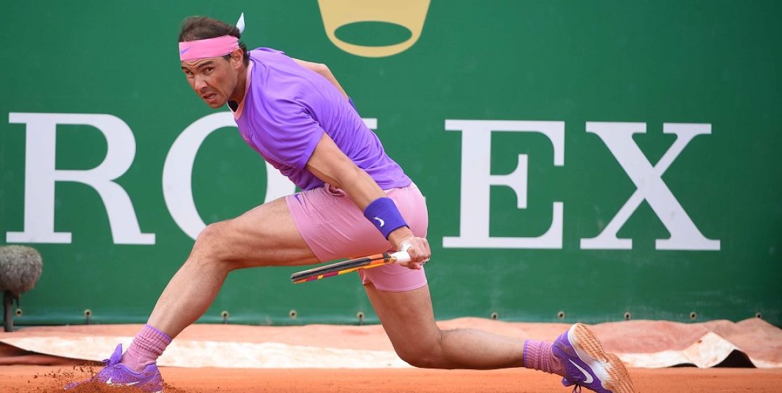 Rafa Nadal slides into a backhand return on red clay